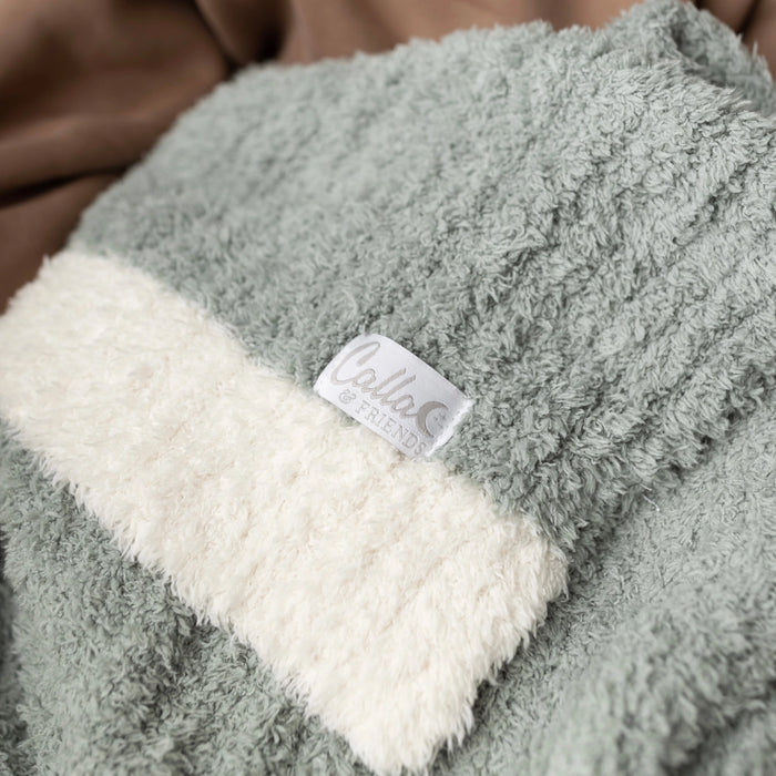 Closeup of sage Alani blanket showing ribbed texture and cream border