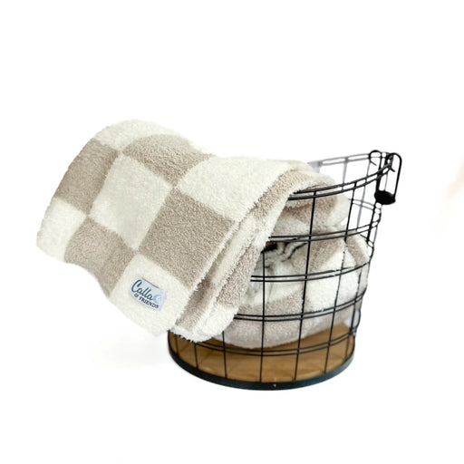 Fawn checkered blanket draped over a wire basket