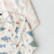 Children's clothing with fish and boat pattern on a light background