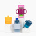 A colorful stack of KiddyTrek cups and holders arranged on white blocks, showing mix-and-match versatility.