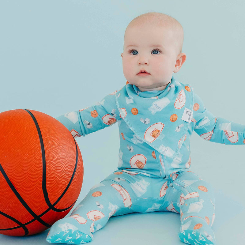 Baby beside a basketball wearing the blue basketball Copper Pearl All Star bandana bib