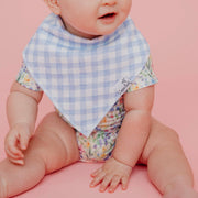 Close-up of the blue gingham Copper Pearl Catherine bandana bib on a seated baby