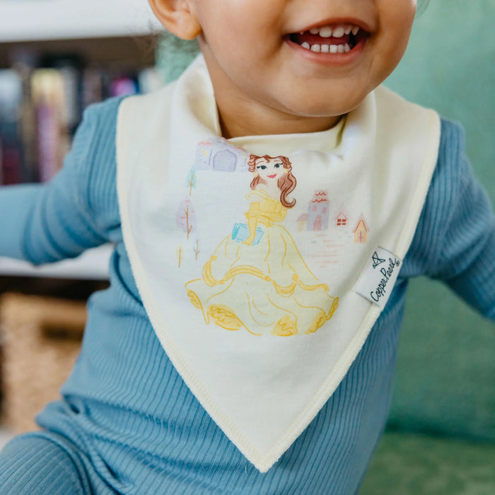 Baby wearing yellow Belle Copper Pearl bandana bib smiling on sofa