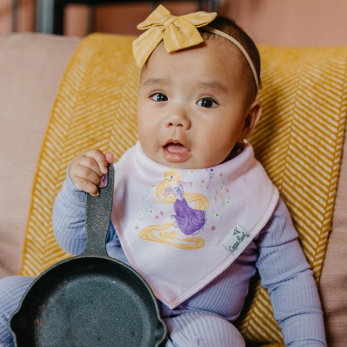 Baby smiling while wearing white Copper Pearl bandana bib with Rapunzel design