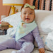 Baby smiling while wearing white Copper Pearl bandana bib with Princess Tiana design