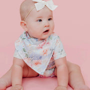 Baby glancing sideways while wearing a floral Copper Pearl Genevieve bandana bib