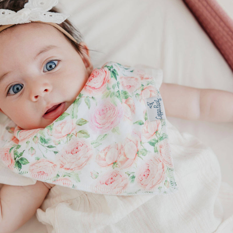 Close-up of a baby wearing the pink rose Copper Pearl Genevieve bandana bib
