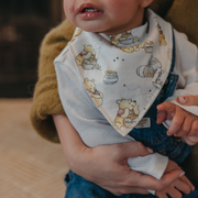 Baby wearing a Copper Pearl Hundred Acre Wood Winnie the Pooh bandana bib