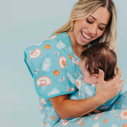 Woman holding a baby with the blue basketball Copper Pearl All Star burp cloth over her shoulder