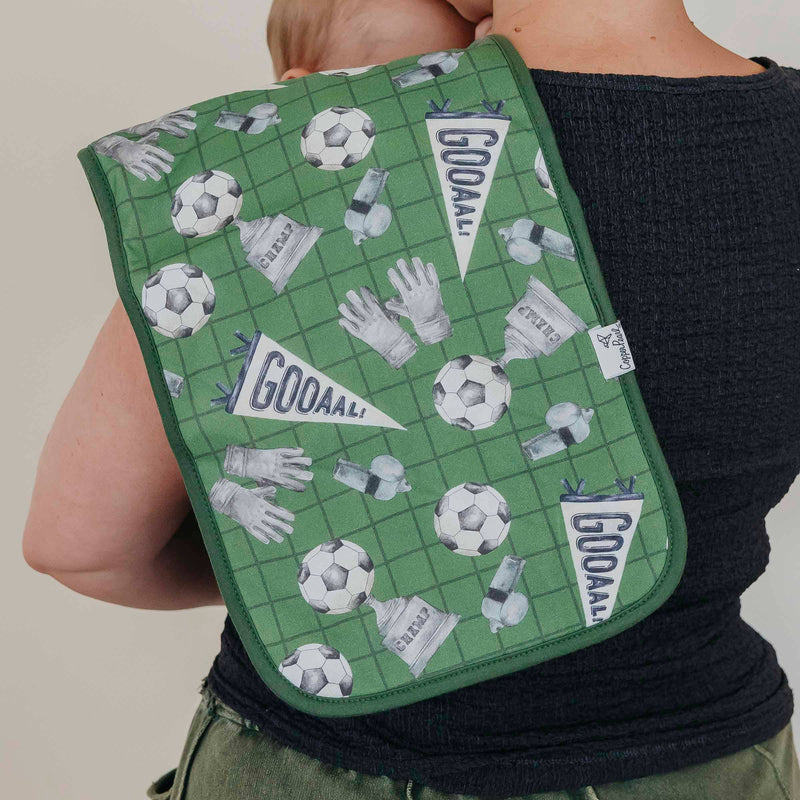 Green soccer print Copper Pearl All Star burp cloth draped over a shoulder, seen from behind