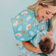 Woman smiling down at a baby with the blue basketball Copper Pearl All Star burp cloth on her shoulder