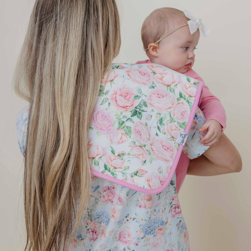 Baby held over a shoulder covered by the pink rose Copper Pearl Genevieve burp cloth