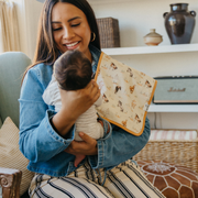 Parent holding baby with a Copper Pearl Cheyenne burp cloth in tan western print over the shoulder