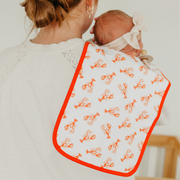 Parent holding baby with a Copper Pearl Fischer burp cloth in lobster print over the shoulder