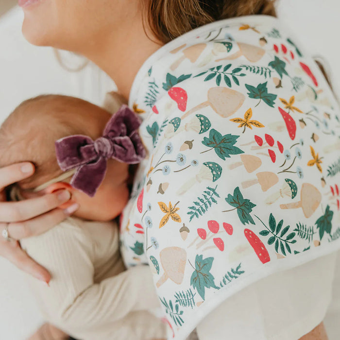 Baby wearing a floral hat being held by a person