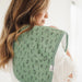 Parent holding baby with green alphabet Copper Pearl burp cloth over shoulder