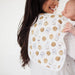 Parent burping baby with cookies and milk Copper Pearl burp cloth over shoulder