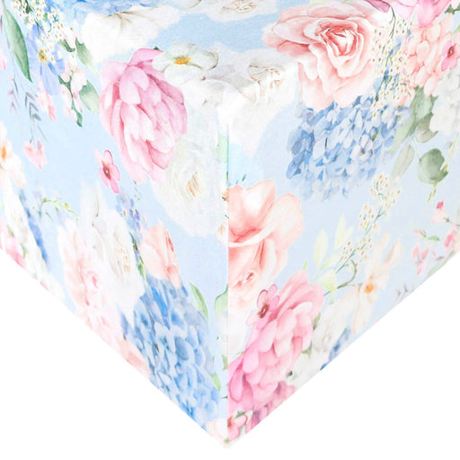 Copper Pearl premium knit fitted crib sheet in Genevieve print, pink and blue florals, shown on a mattress corner