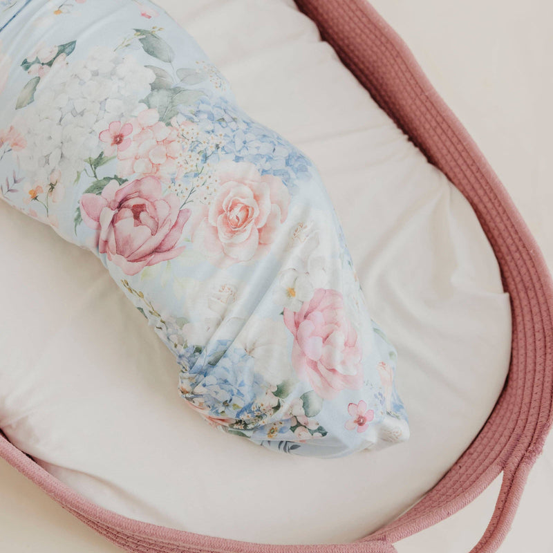 Close-up of the Copper Pearl Genevieve floral knit swaddle blanket wrapped around a baby