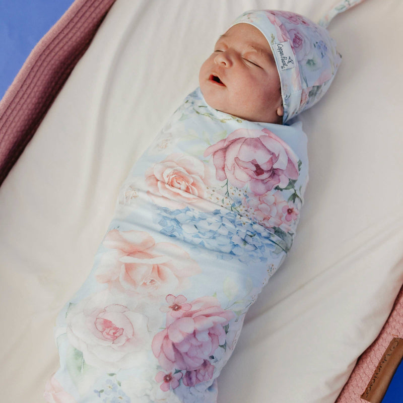 Sleeping baby swaddled in the Copper Pearl Genevieve knit swaddle blanket wearing a matching hat
