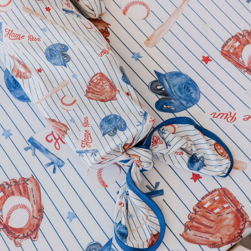 Close-up of the knotted bottom and navy trim on the Copper Pearl All Star newborn gown