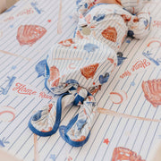 Overhead view of a baby wearing the Copper Pearl All Star newborn knotted gown