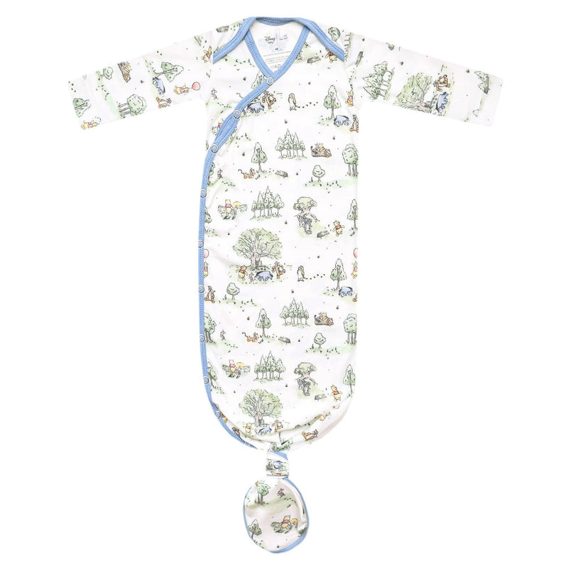 Copper Pearl newborn knotted gown in Hundred Acre Wood print, a soft green storybook woodland pattern with blue trim, laid flat