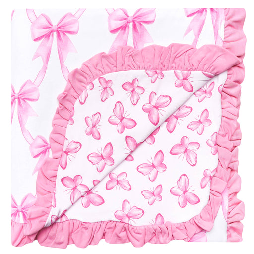 A square baby blanket or quilt with a white background, decorated with pink watercolor butterflies and bows, finished with a thick pink ruffled border.