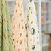 three baby swaddle blankets with different patterns hanging on a rack.