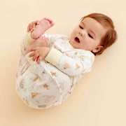 Baby wearing convertible coverall while lying on back