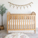 Nursery room with wooden crib dressed in Charlie Farmhouse Goose crib sheet