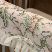 Floral patterned fabric with ruffled edge on a neutral background