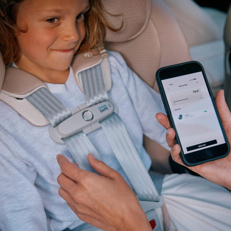 Parent checking SensorSafe alerts on a phone beside a child in the Cybex Callisto G 360