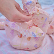 Baby's feet in colorful fish-patterned socks on a soft surface