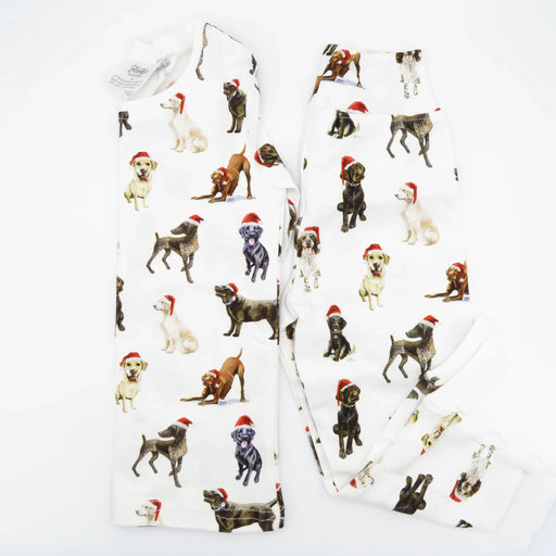 Flatlay of Saltwater Swaddles Santa Dogs kids pajamas with watercolor holiday dog illustrations on white background