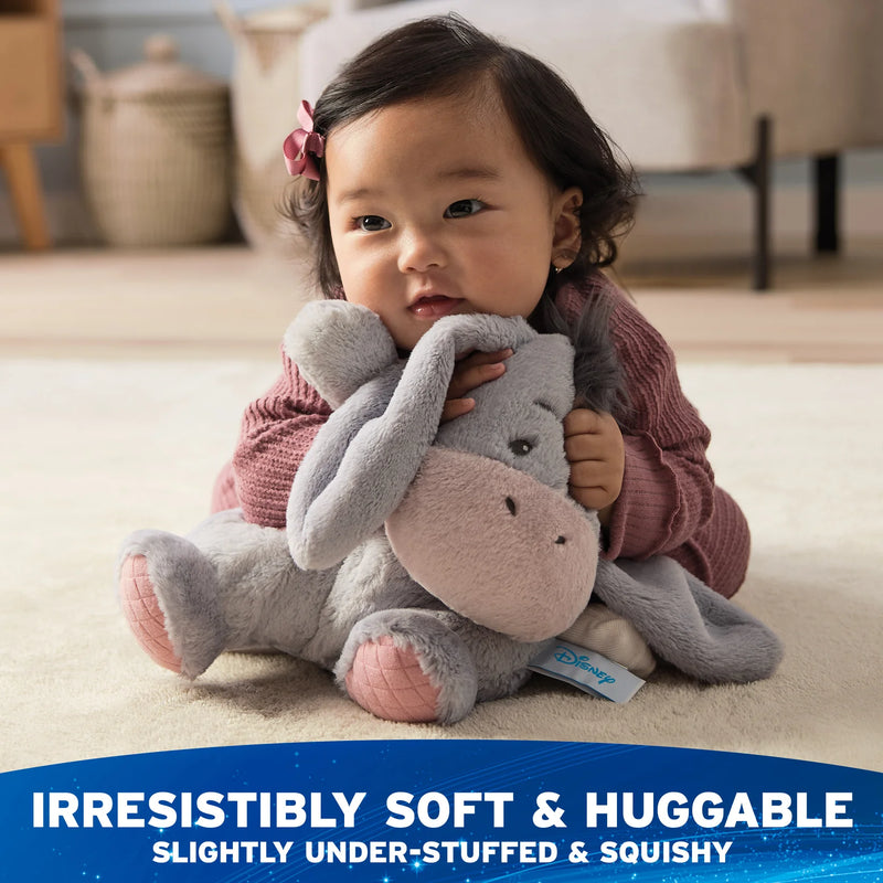 Child cuddling Oh So Snuggly Eeyore plush during playtime