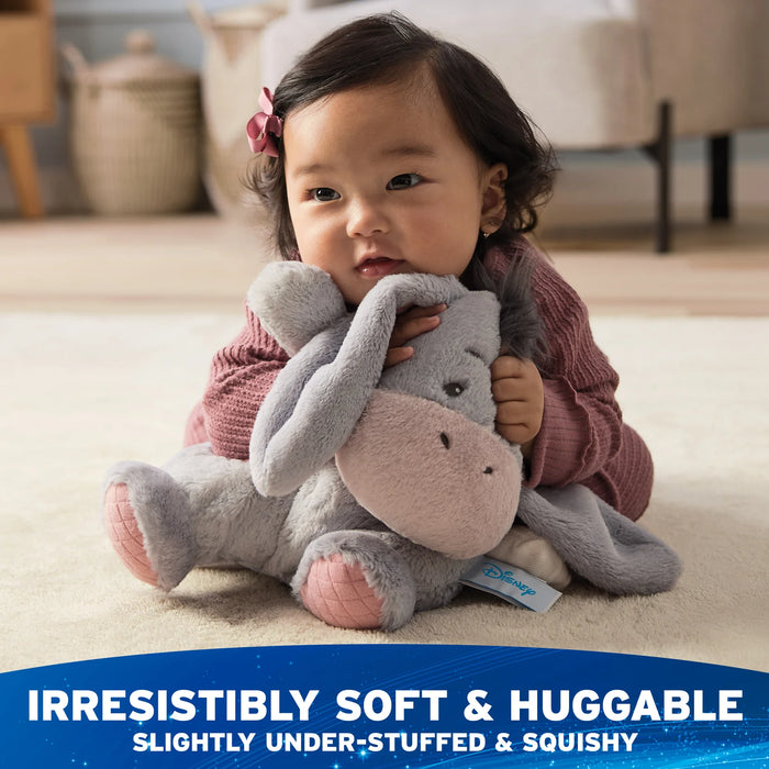 Child cuddling Oh So Snuggly Eeyore plush during playtime
