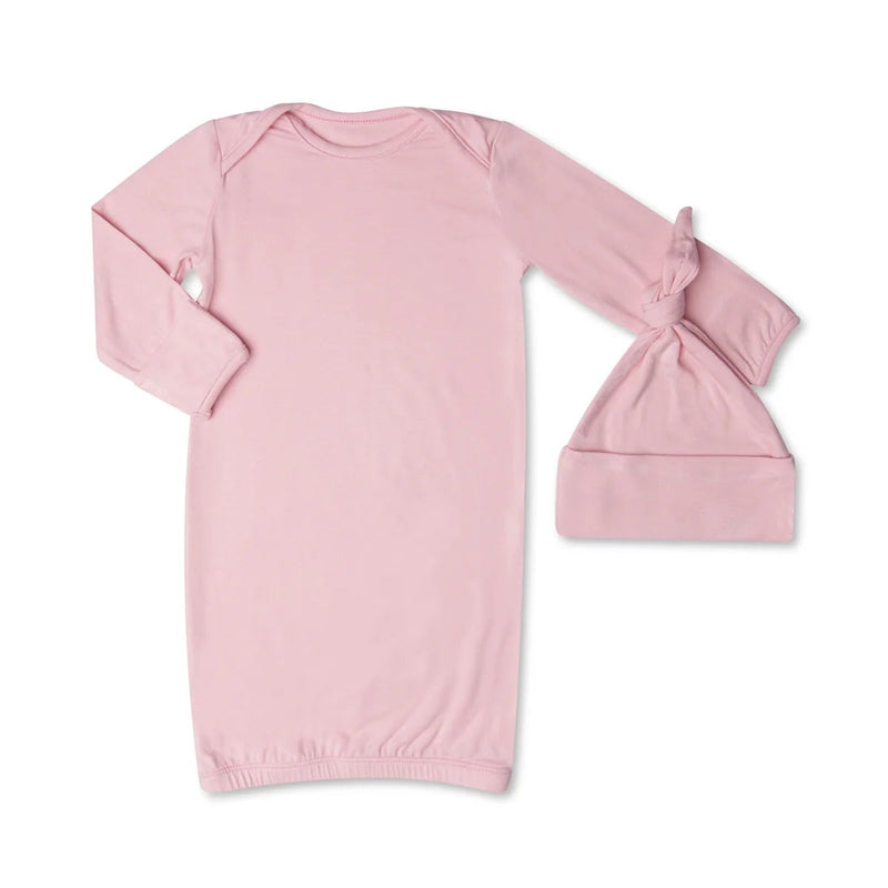 Pink baby gown and hat set on a white background