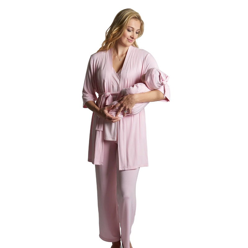 Woman wearing a pink  robe holding a matching newborn outfit on a white background