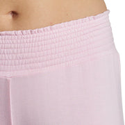 Close-up of a person wearing light pink sweatpants on a white background