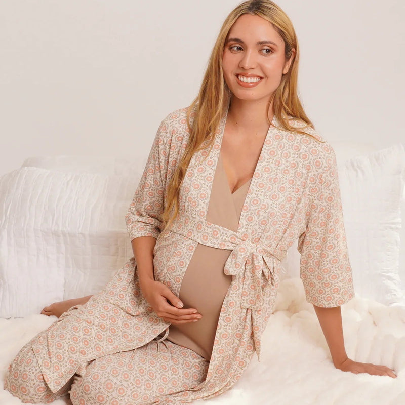 Woman in a floral robe sitting on a white bed