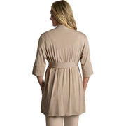 Woman wearing a beige outfit with a belt on a white background