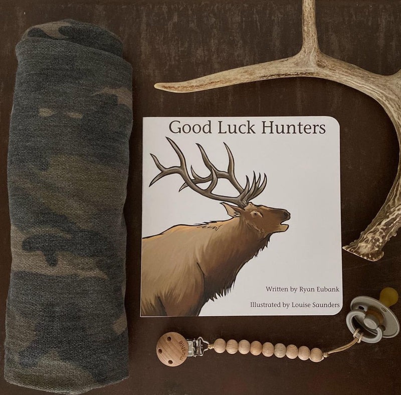 Good Luck Hunters board book displayed with antlers and a camo blanket