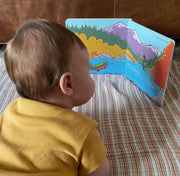 Baby looking at the open Match the Hatch board book