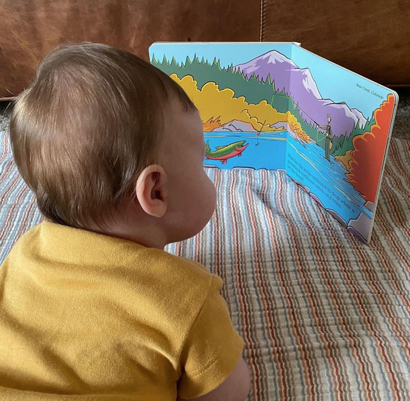 Baby looking at the open Match the Hatch board book