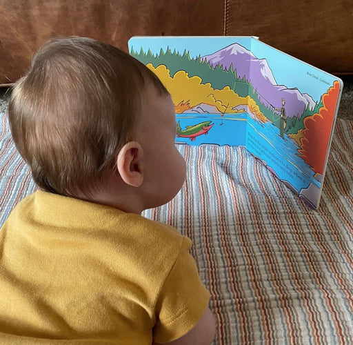 Baby looking at the open Match the Hatch board book