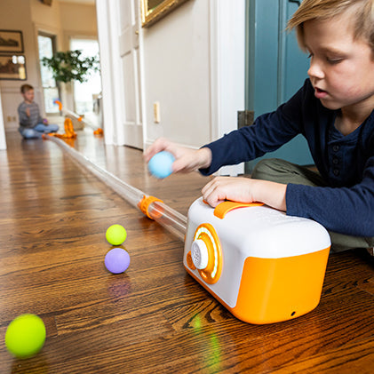 Child playing with a toy on a wooden floor