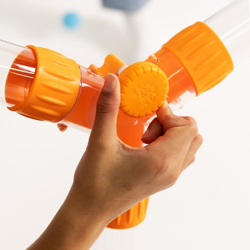 Hand holding an orange and clear toy  against a white background