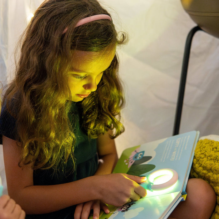 girl holding magic magnifier as the page lights up