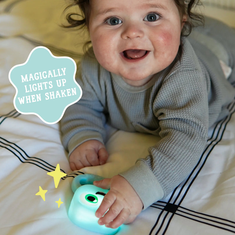 smiling baby shaking blair light up rattle on play mat